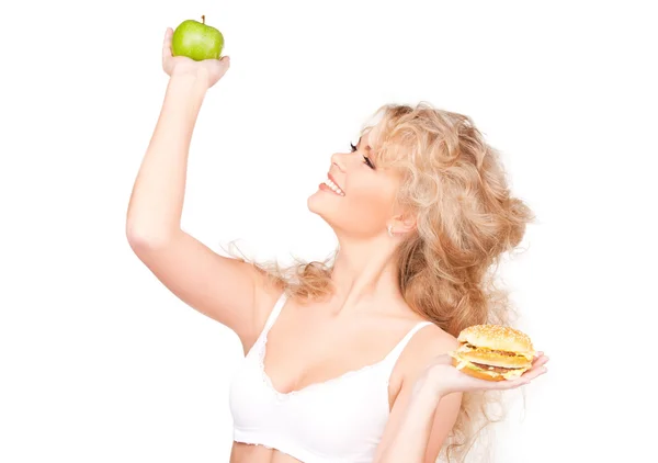 Mujer eligiendo entre hamburguesa y manzana — Foto de Stock