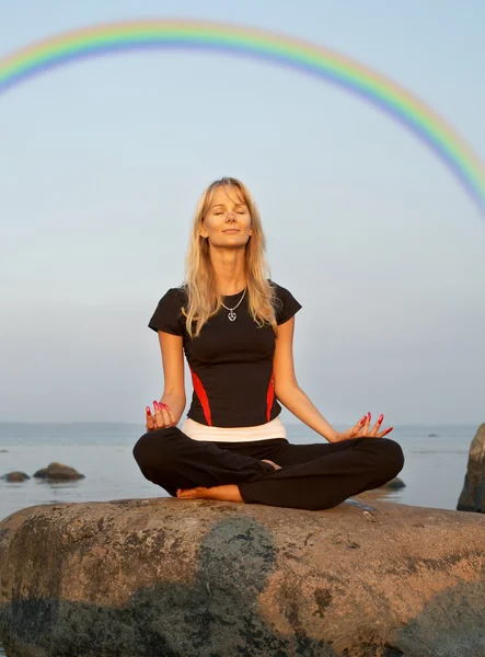 Meditation at the seashore under rainbow — Stock Photo, Image