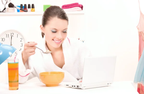 Comer computador portátil mulher — Fotografia de Stock