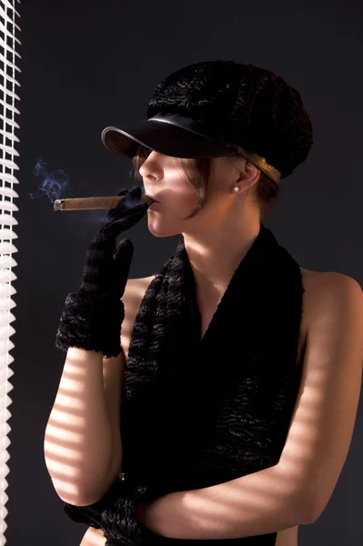 Жінка в чорному астрахані палить сигару — стокове фото