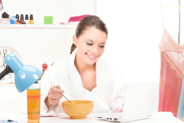 Comer mujer con ordenador portátil — Foto de Stock