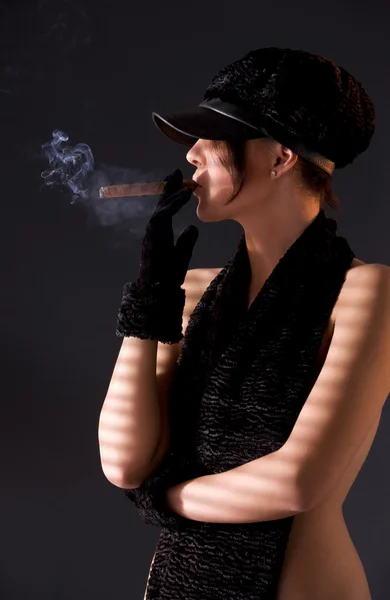 Woman in black astrakhan smoking cigar — Stock Photo, Image