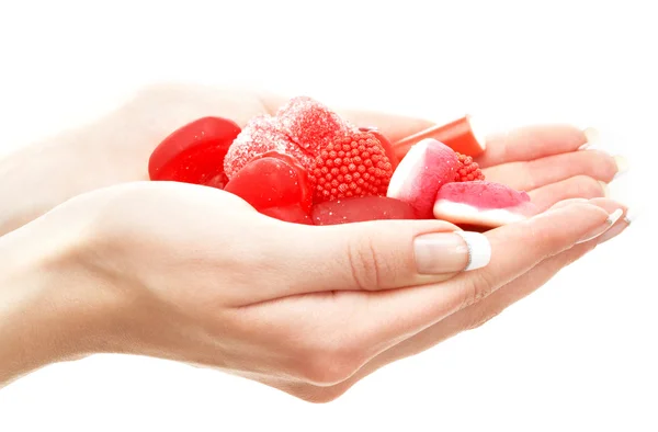 Ruce plné červené bonbony — Stock fotografie