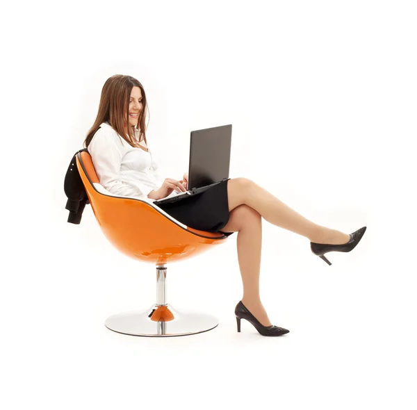 笔记本电脑在橙色的椅子上做买卖的商人 — 图库照片