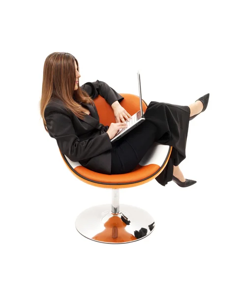 Elegancka kobieta z laptopa w pomarańczowy fotel — Zdjęcie stockowe