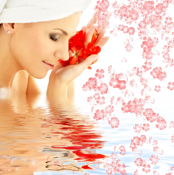 Senhora com pétalas vermelhas e flores na água — Fotografia de Stock