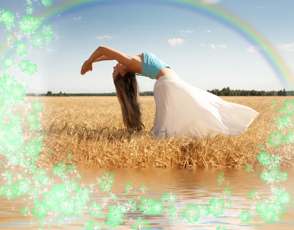 Растягивающаяся женщина с радугой, водой и цветами — стоковое фото
