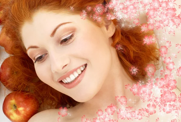 Lovely redhead with red apples and flowers — Stock Photo, Image
