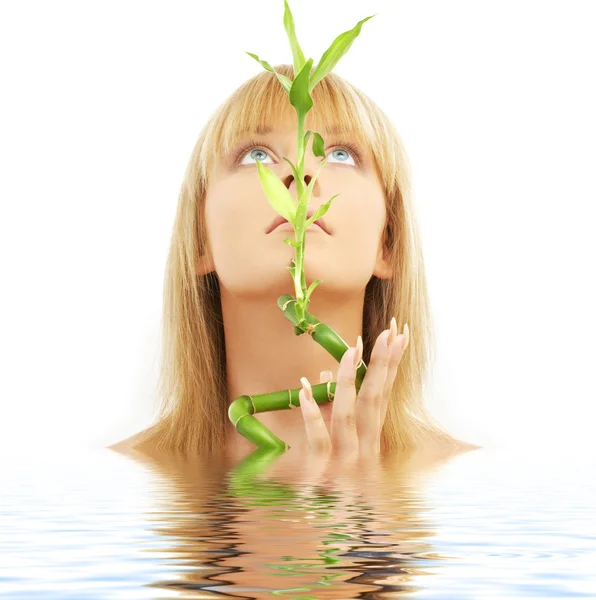Härlig blond med bambu i vatten — Stockfoto