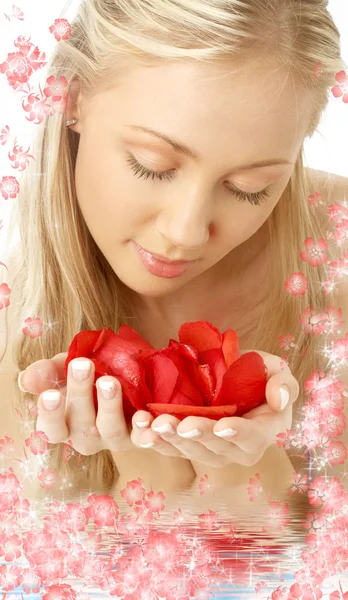Прекрасная блондинка в воде с красными лепестками роз — стоковое фото