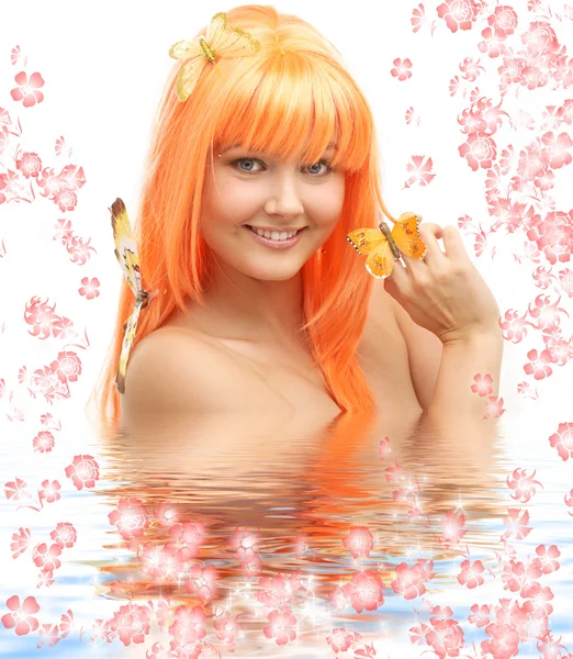 Mariposa chica en el agua con flores — Foto de Stock
