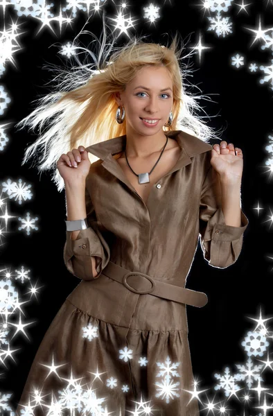 Танцующая блондинка в коричневом платье со снежинками — стоковое фото