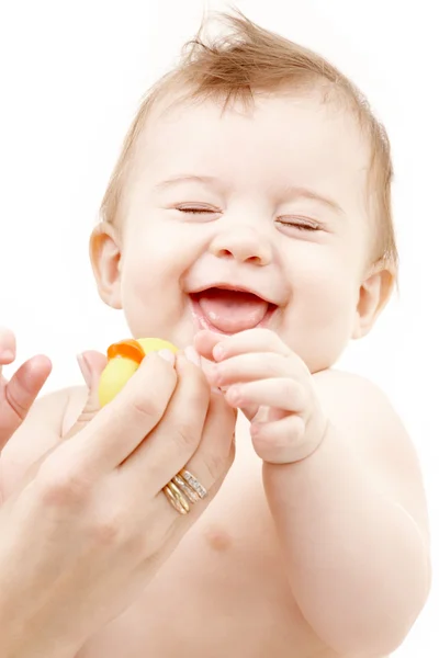 Smějící se chlapeček v rukou matka s gumovou kachnu — Stock fotografie