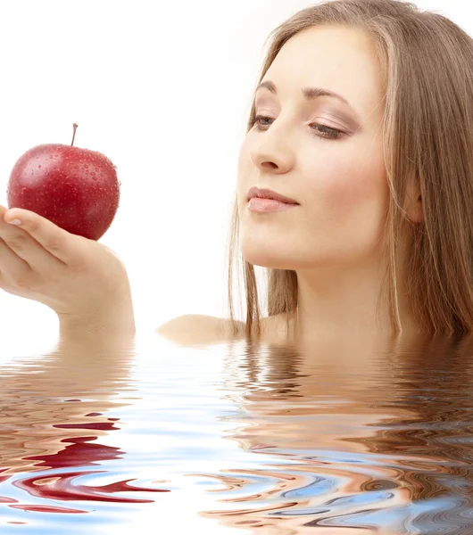 Woman with red apple in water — Stock Photo, Image