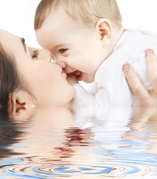 물에 아기를 키스 하는 행복 한 어머니 — 스톡 사진
