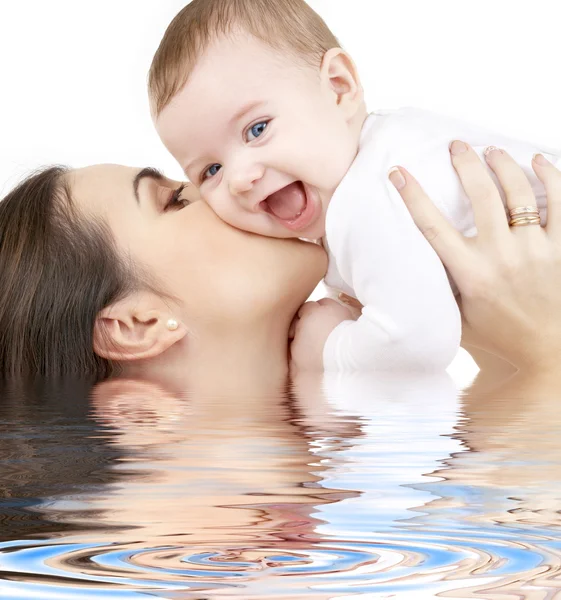 Laughing baby playing with mother in water — Stock Photo, Image