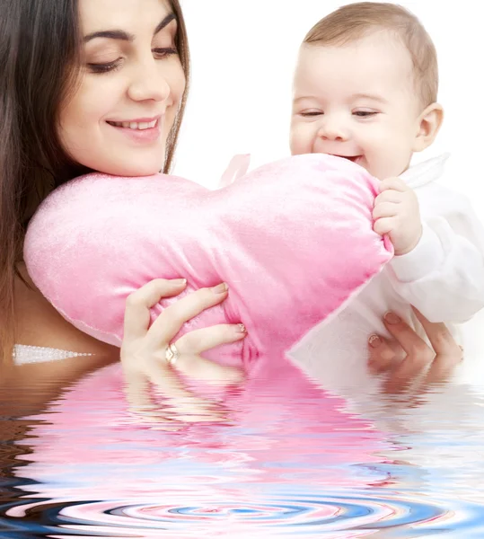 Ребенок и мама с подушкой в форме сердца — стоковое фото