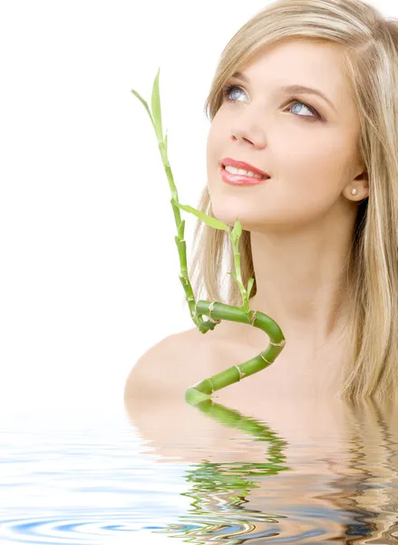 Blue-eyed blonde with bamboo in water — Stock Photo, Image