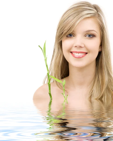 Blauäugige Blondine mit Bambus im Wasser — Stockfoto