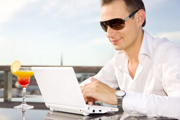 Geschäftsmann in der Freizeit mit Laptop und Cocktail — Stockfoto