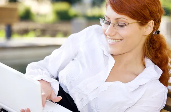Mujer de negocios sonriente con computadora portátil — Foto de Stock