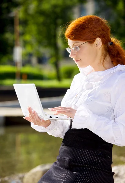 Empresária com laptop no parque — Fotografia de Stock