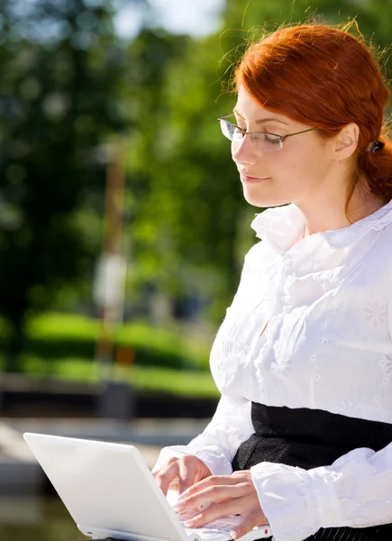 Mujer de negocios con portátil en el parque — Foto de Stock