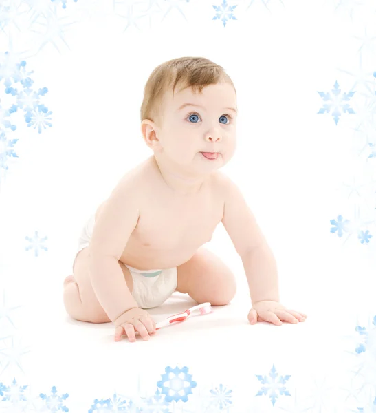 Baby boy in diaper with toothbrush sticking tongue out — Stock Photo, Image