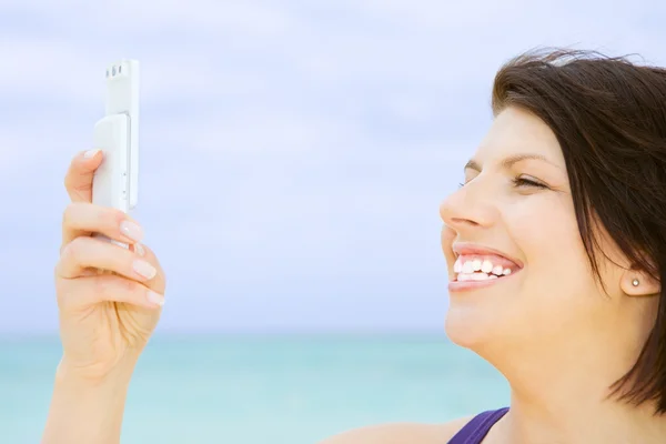 Mulher feliz com telefone na praia — Fotografia de Stock