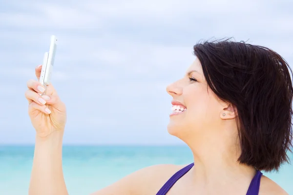 Mulher feliz com telefone na praia — Fotografia de Stock