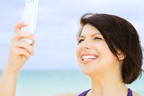 Mujer feliz con teléfono en la playa — Foto de Stock