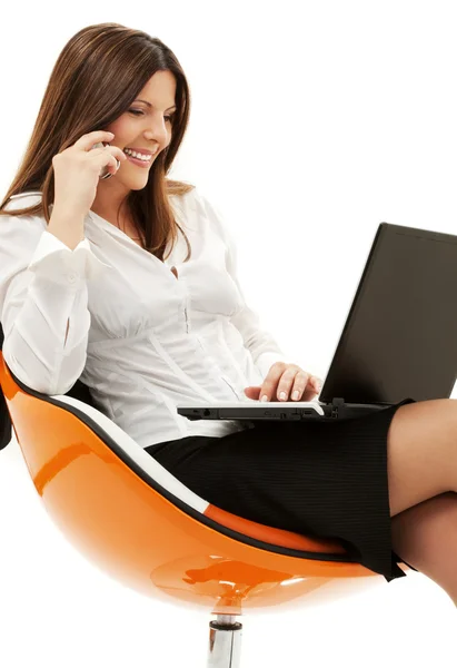 Mujer de negocios en silla con ordenador portátil y teléfono —  Fotos de Stock