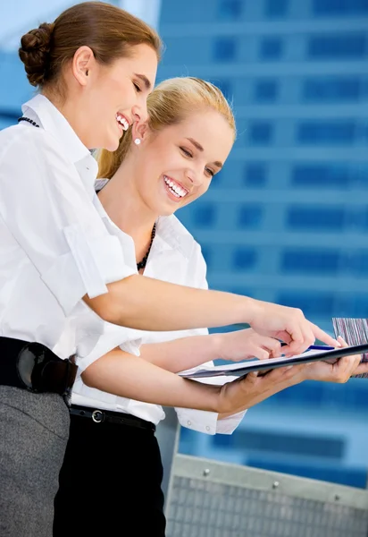 Zwei glückliche Geschäftsfrauen mit Papierdiagramm — Stockfoto