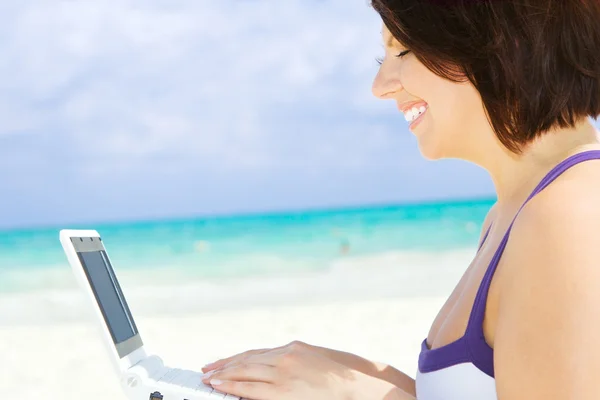 Nő a tengerparton laptop számítógéppel — Stock Fotó