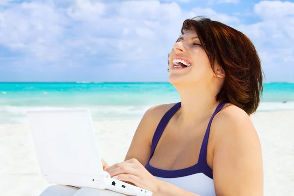 Kvinna med bärbar dator på stranden — Stockfoto
