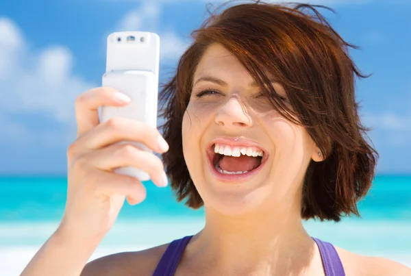 Femme heureuse avec téléphone sur la plage — Photo