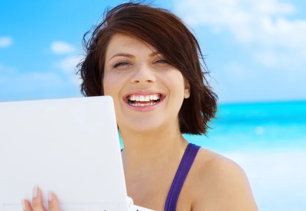 Mulher com computador portátil na praia — Fotografia de Stock