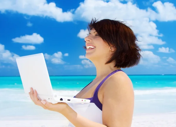Femme avec ordinateur portable sur la plage — Photo