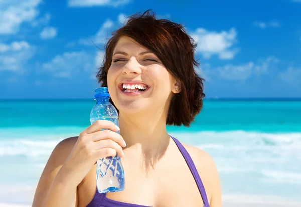 Счастливая женщина с бутылкой воды — стоковое фото