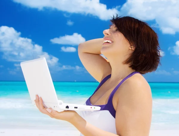 在海滩上的膝上型计算机的女人 — 图库照片