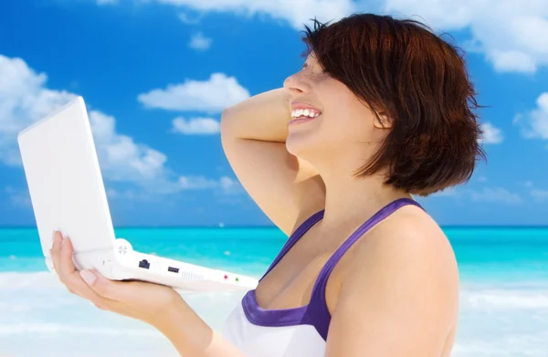 Mujer con ordenador portátil en la playa —  Fotos de Stock