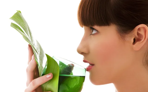 Женщина с зеленым листом и стаканом воды — стоковое фото
