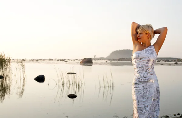 Loira bonita em vestido extravagante na praia — Fotografia de Stock
