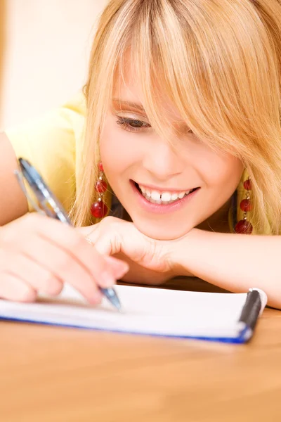 Девочка-подросток с блокнотом и ручкой — стоковое фото