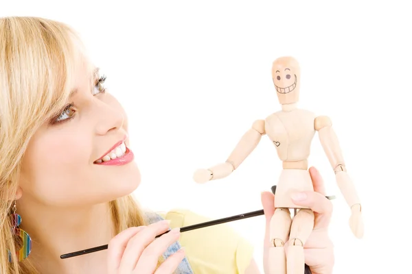 Happy teenage girl with wooden model dummy — Stok fotoğraf