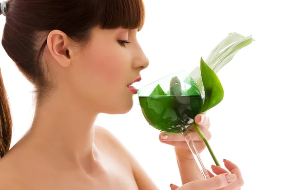 Kvinna med gröna blad och glas vatten — Stockfoto