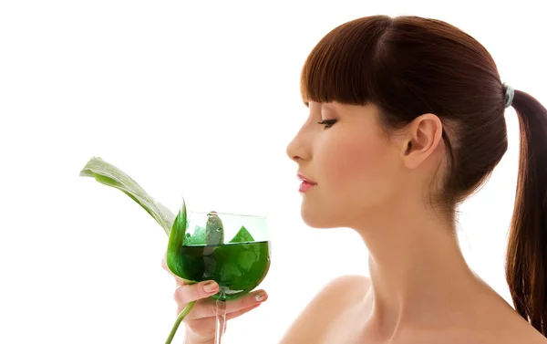 Kvinna med gröna blad och glas vatten — Stockfoto