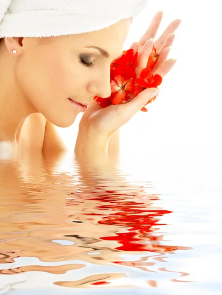 Dame met rode bloemblaadjes in water — Stockfoto
