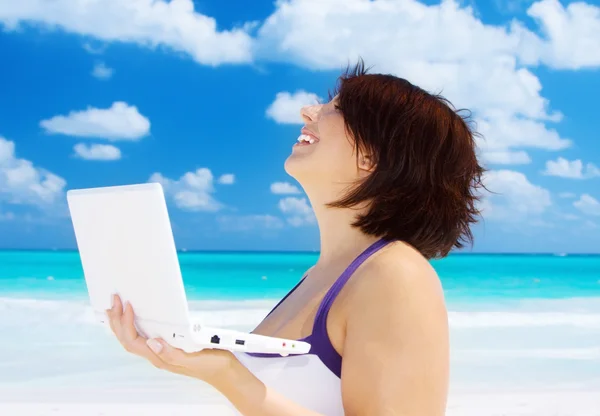 Donna con computer portatile sulla spiaggia Fotografia Stock