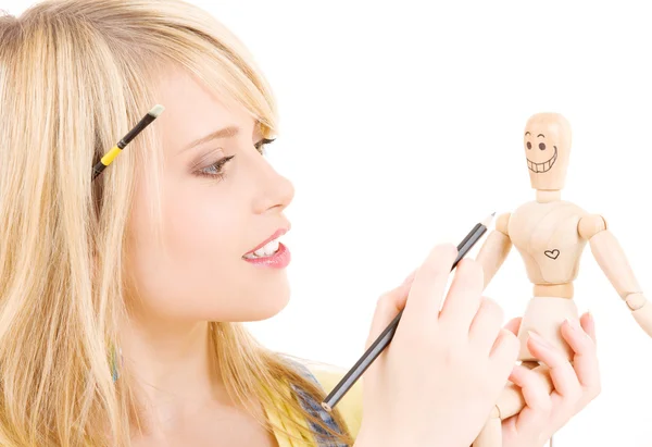 Happy teenage girl with wooden model dummy Royalty Free Stock Photos